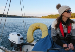Mam on Menai Strait, motoring a J80 sailboat - Cushion supporting heragainst guard rail.